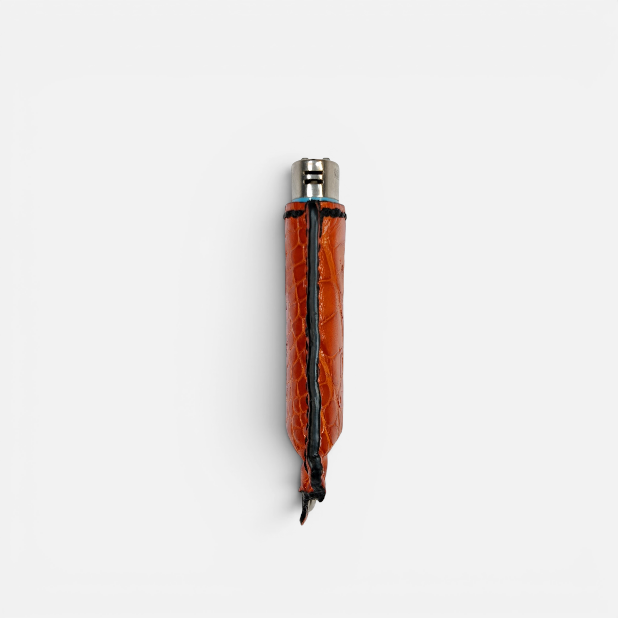 Détail des écailles du cuir d'alligator orange sur l'étui à briquet MRLM